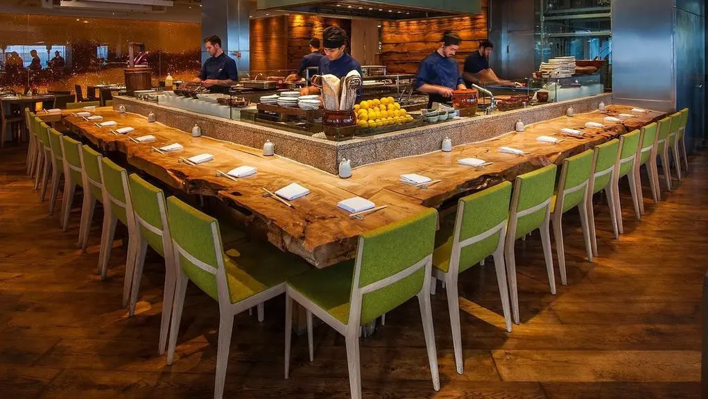 Seating area with green chairs inside Roka restaurant