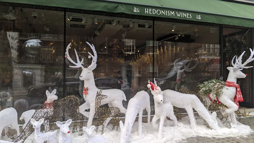 Festive window display with reindeer decorations at Hedonism Wines in Mayfair