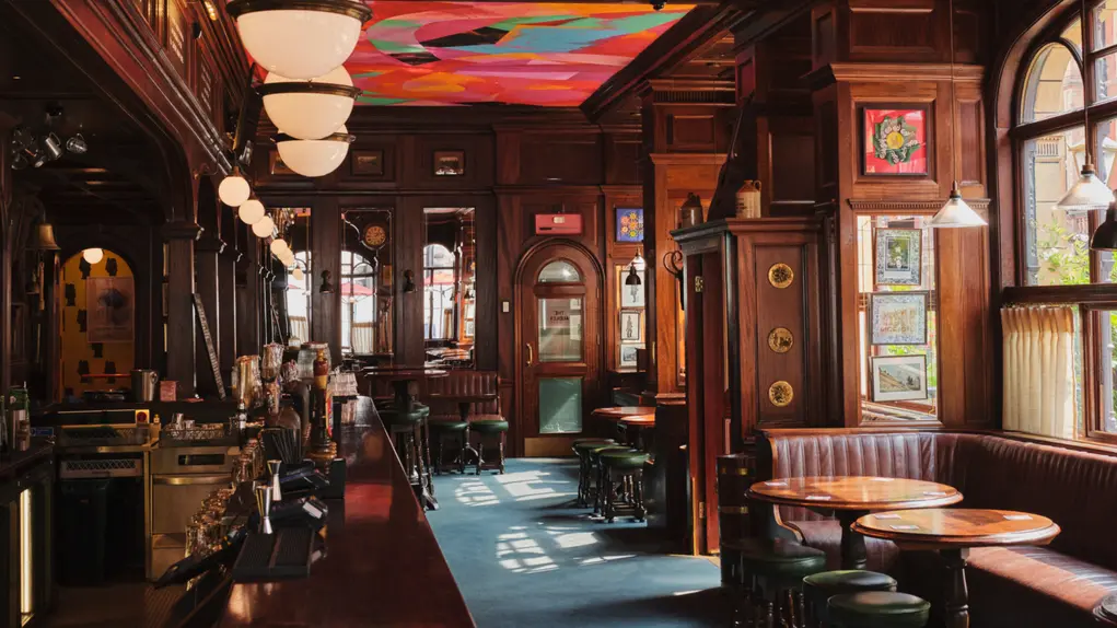 The inside of The Audley Public House with its brightly painted ceiling and mahogany bar