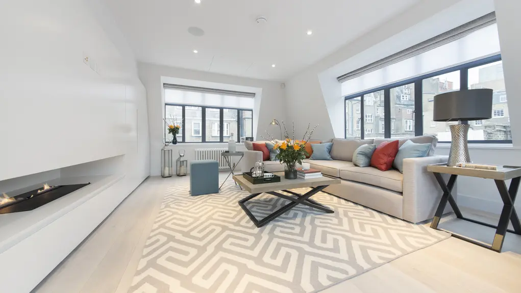 A large living room with windows on two walls and a large sofa