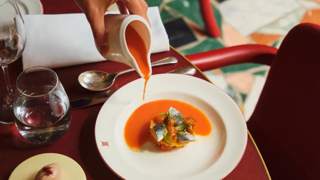 Sauce being poured onto a dinner plate