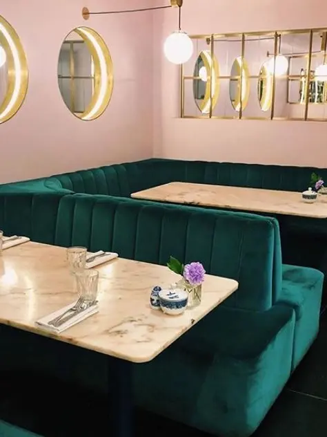 Green velvet booths inside NAC Mayfair