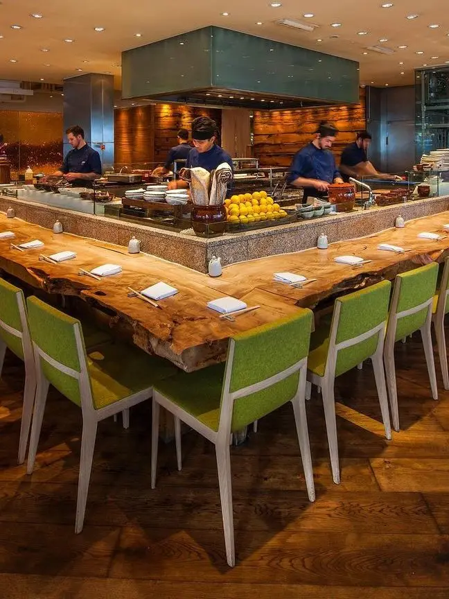 Seating area with green chairs inside Roka restaurant