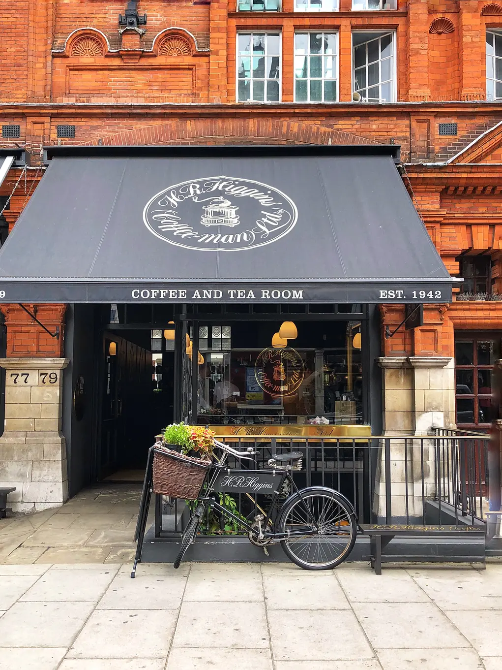 Coffee shop with a bicycle outside and a black awning