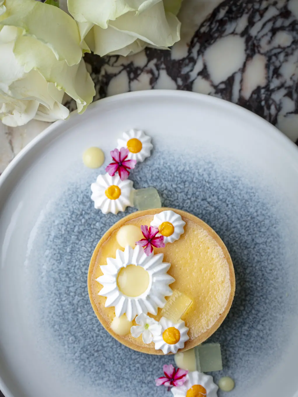 A plate showing a cake with daisy designs