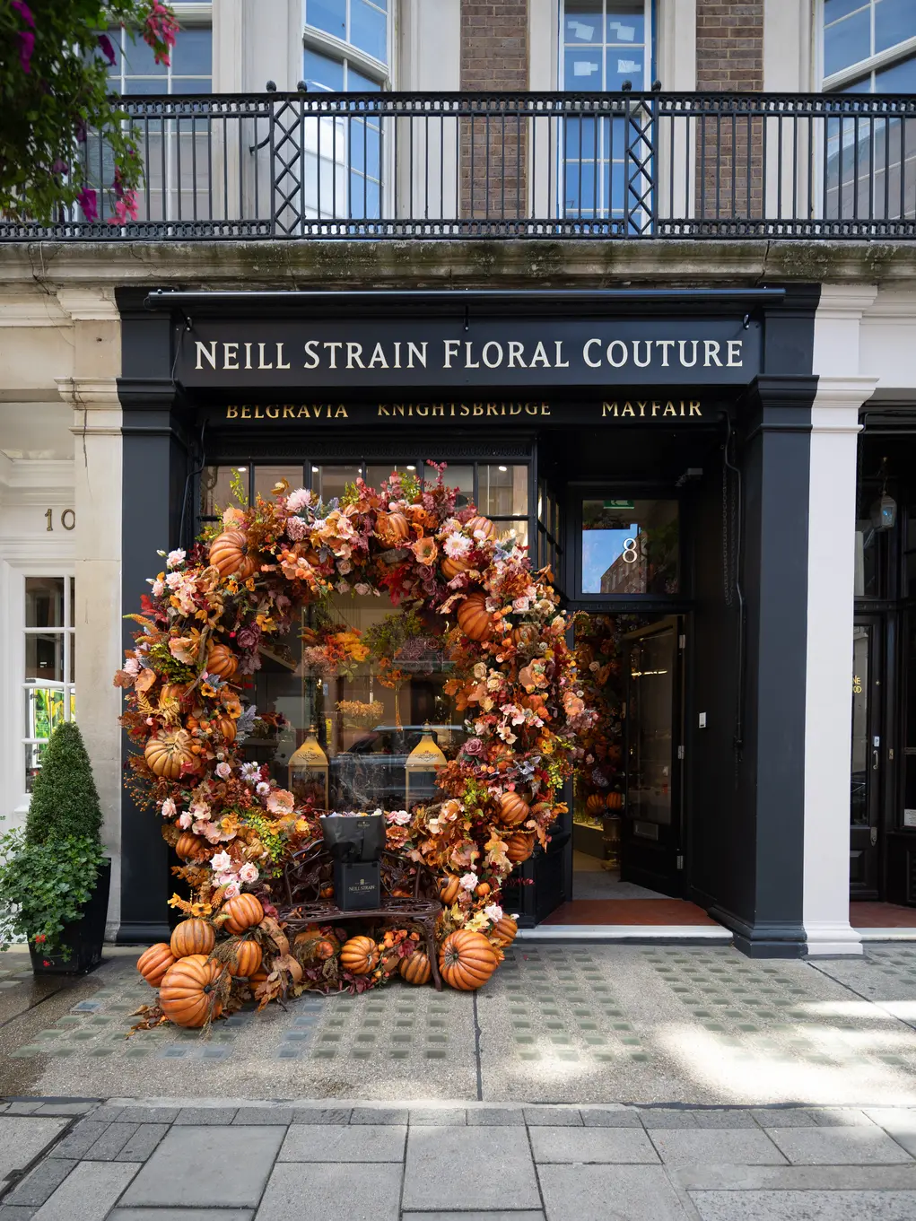 The shopfront of Neill Strain with an archway of pumpkins and autumn foliage