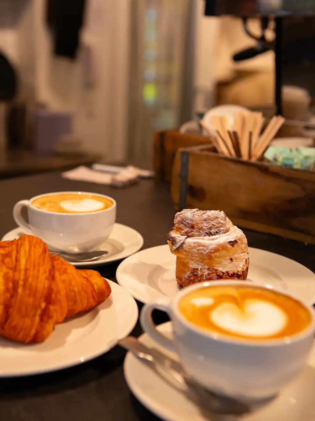 Two coffees, a croissant and a cinnamon bun