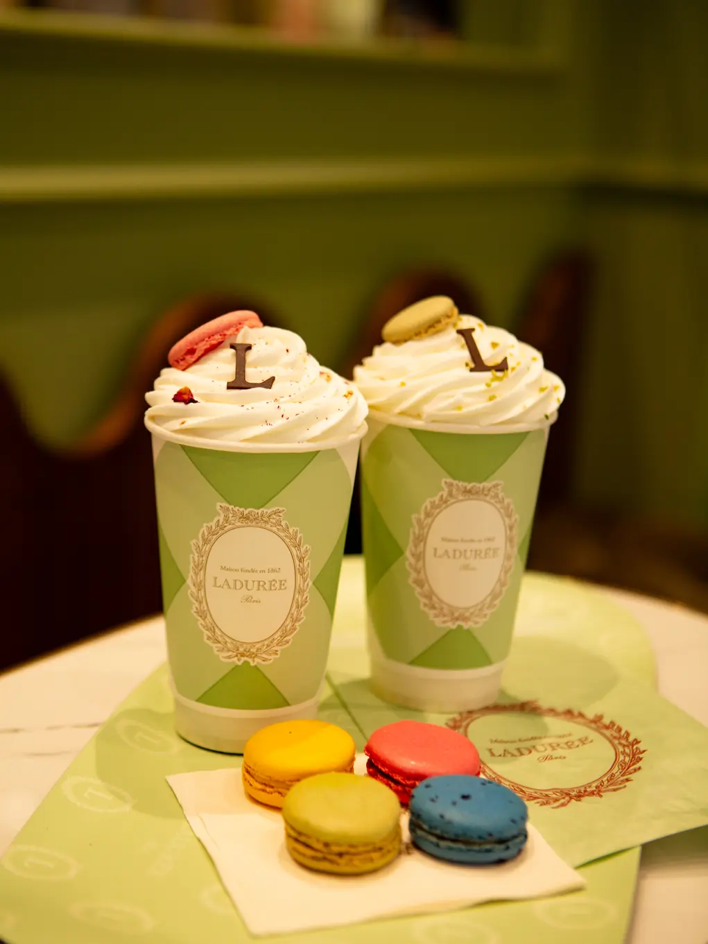 Two hot chocolates with cream and four macarons