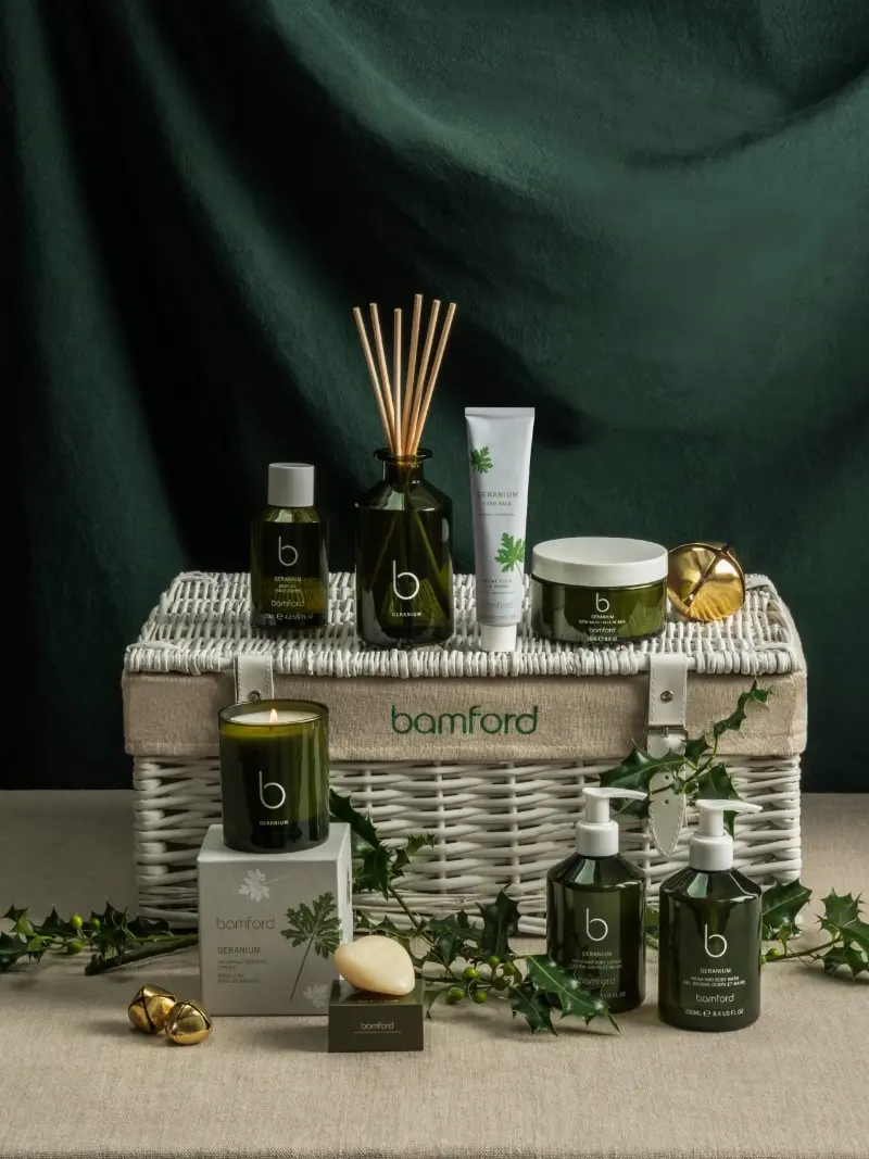 A white basket hamper showcasing Bamford's signature 'geranium' bath, body, and home fragrance gifts in a stylish presentation.