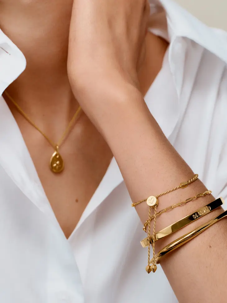 A woman's arm with gold bracelets
