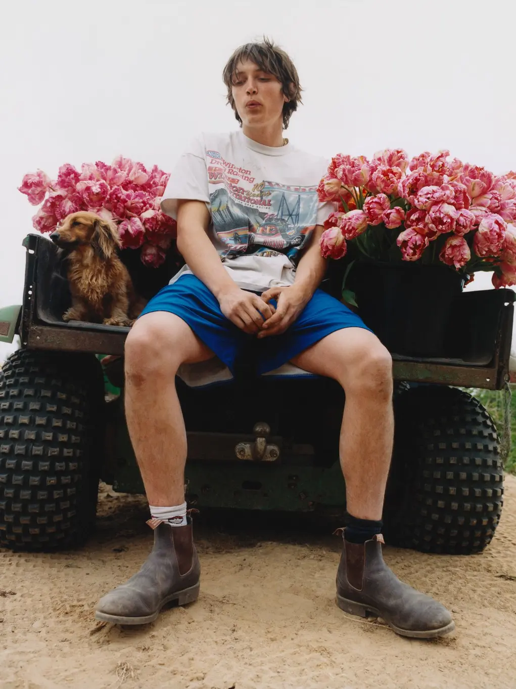 A man sat between two bunches of flowers