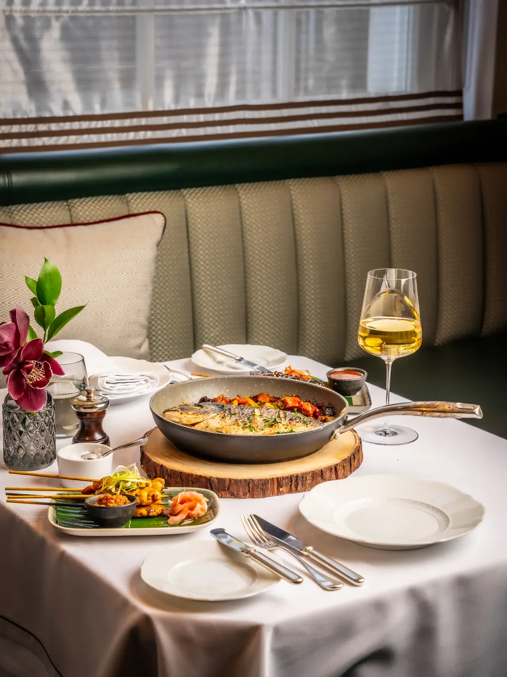 A table laid with food and a glass of wine