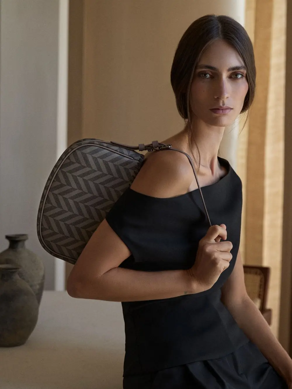 A woman in a black dress with a handbag