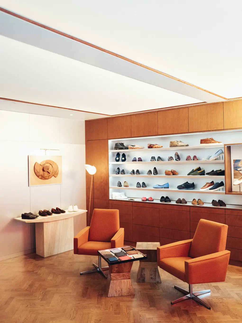 Two orange chairs and shelves of shoes at Arthur Sleep