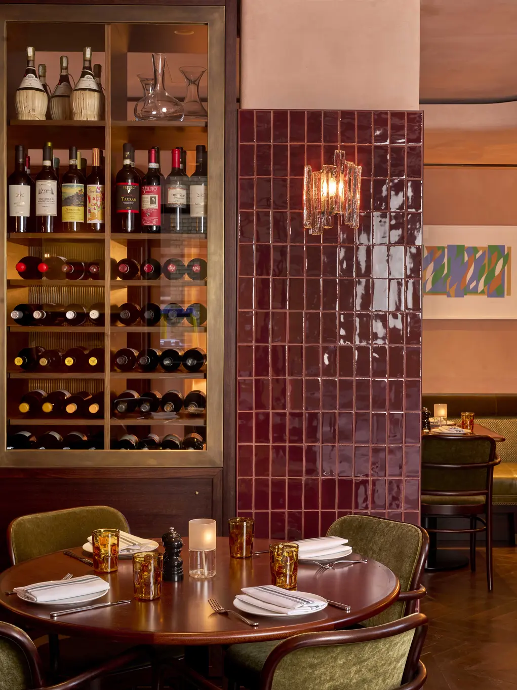 A table and chairs with a wine cabinet in the background