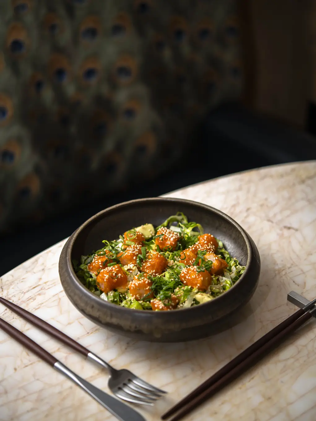 A dish of food next to a knife and fork 