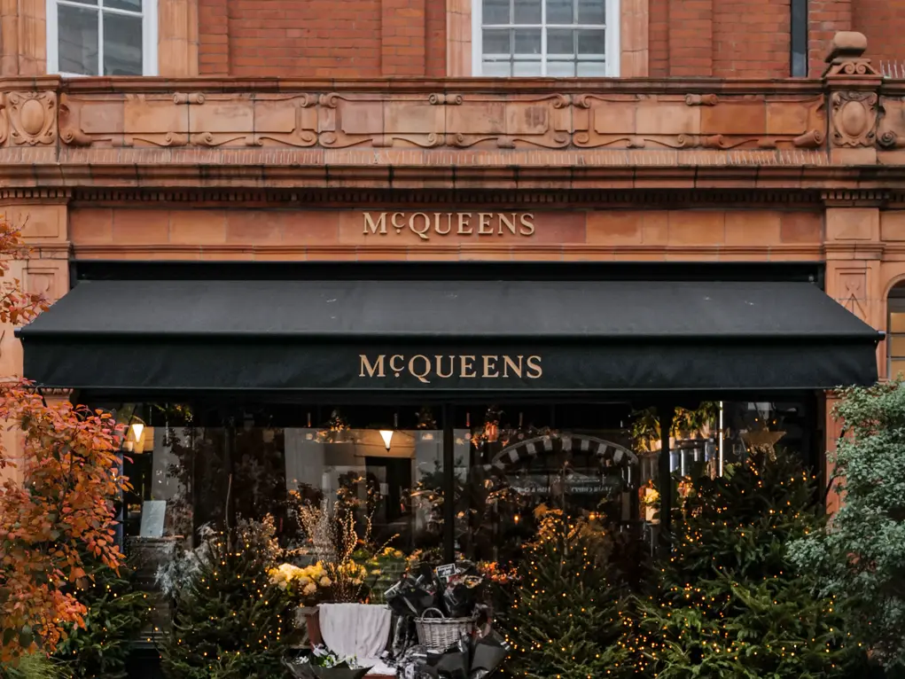 McQueens storefront on Brook Street Mayfair, decorated with seasonal flowers and lights