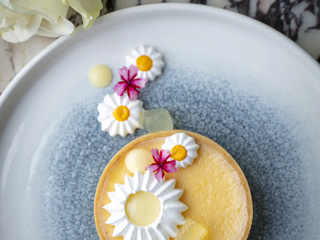 A plate showing a cake with daisy designs
