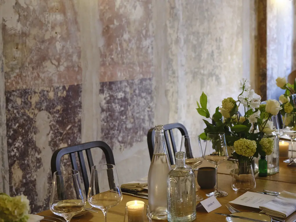 A dining table decorated for a wedding with white flowers, candles and name tags