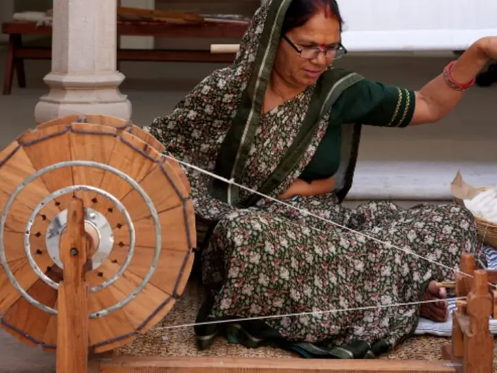 A woman is using a hand loom