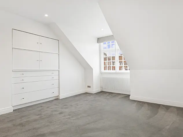 An empty room with white walls and wooden floors