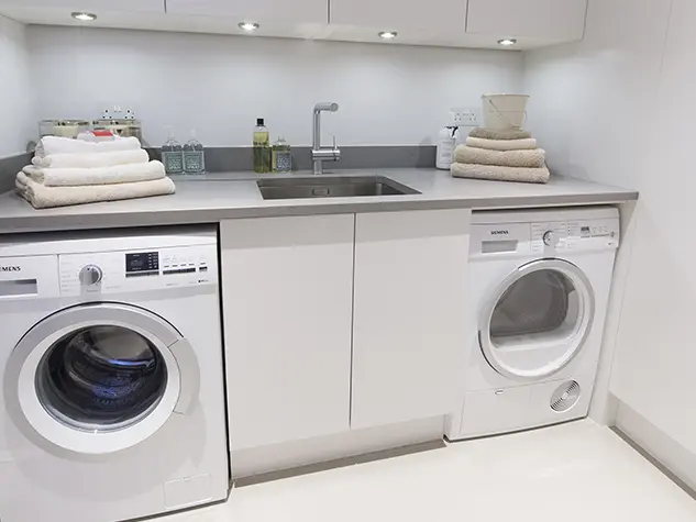 A utility room with washing machine, dryer and sink