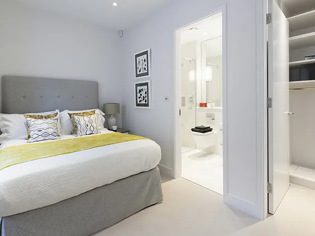 A bedroom with a bed and fitted wardrobe