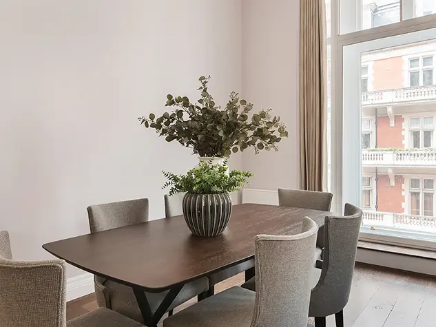 A room with a dining table and chairs