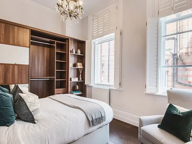 A bedroom with a double bed and an armchair
