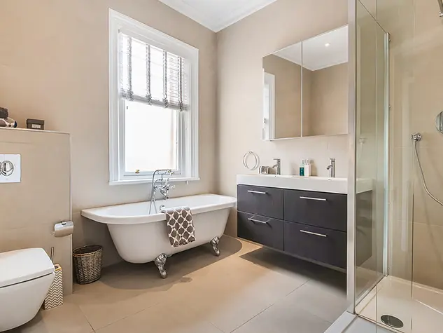 Bathroom with a white claw foot bath tub, a toilet, sink and walk-in shower