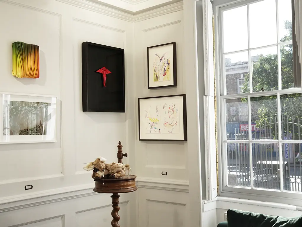 A room with pictures on the wall and a window