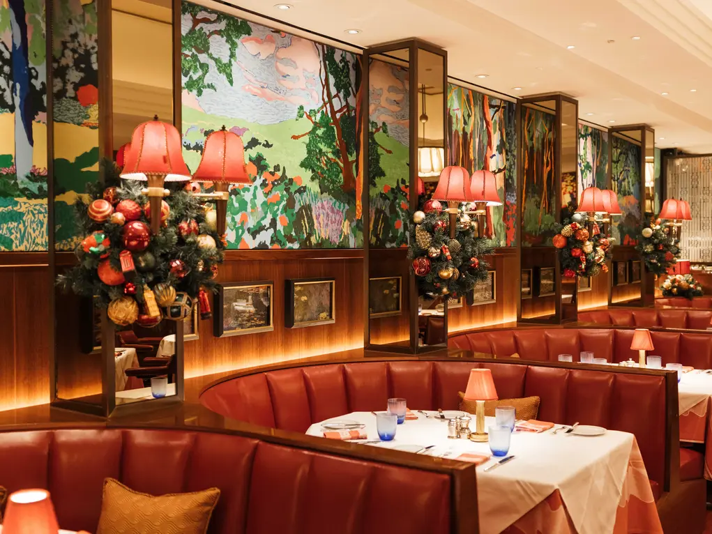 A restaurant with booth seating and Christmas decorations 
