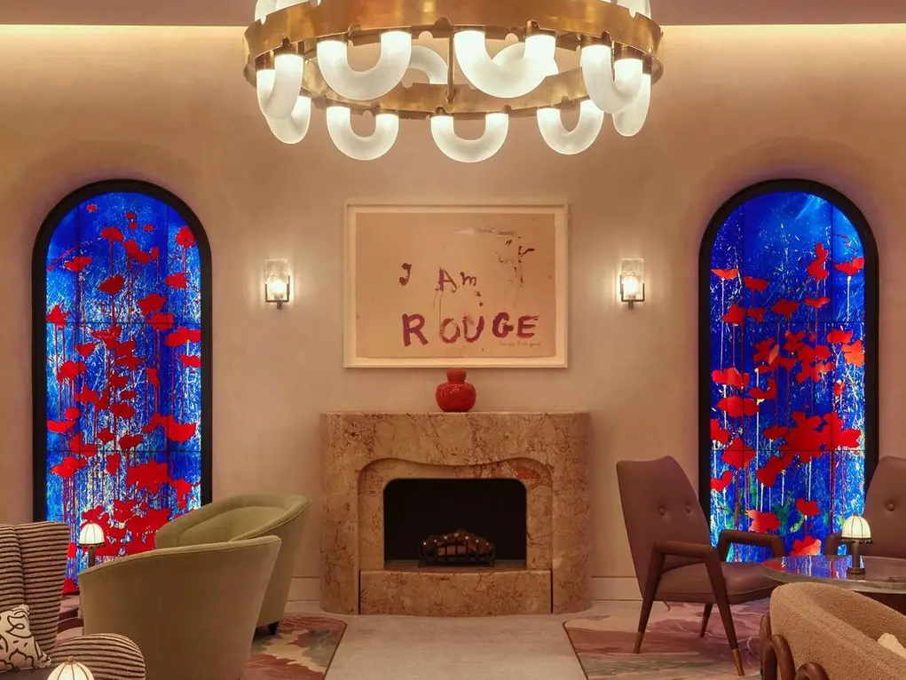 A fireplace with two large blue floral artworks and a large chandelier