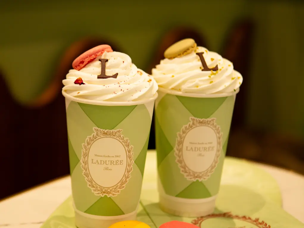 Two hot chocolates with cream and four macarons