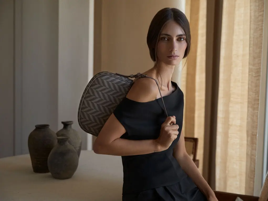 A woman in a black dress with a handbag
