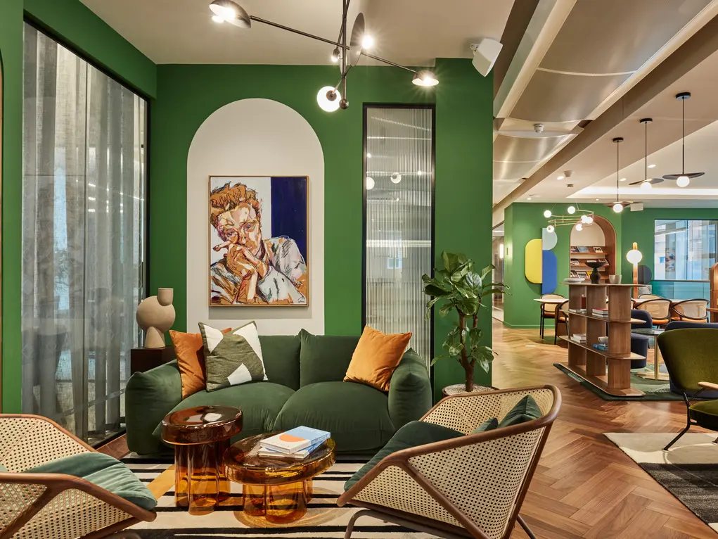 An office with a green sofa and green walls