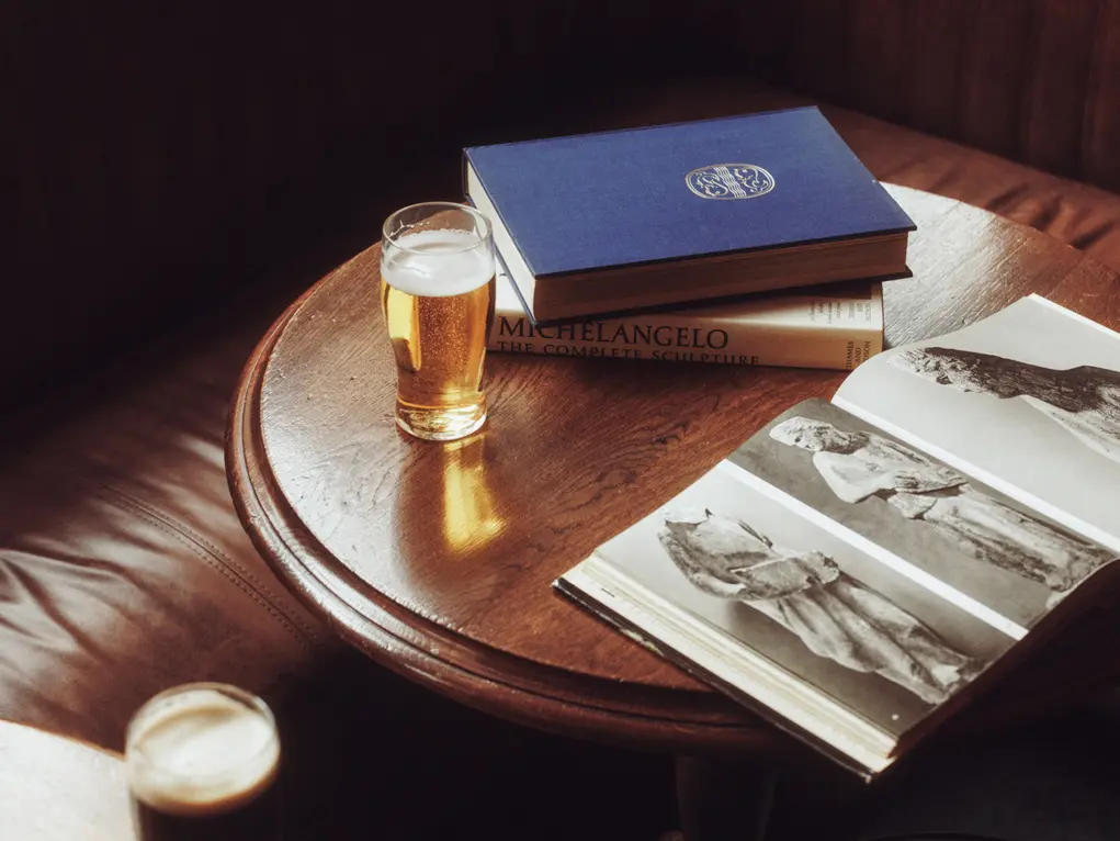 Books on a table with a pint 